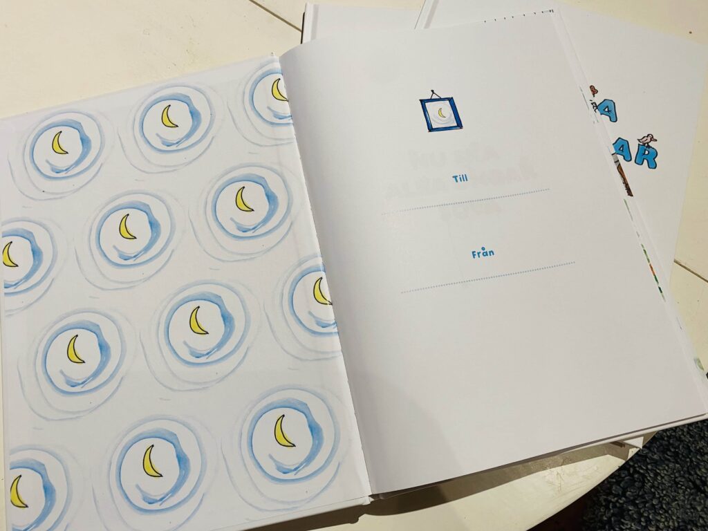 Sida med mönster av månar i cirklar samt en dedikationssida med fälten "Till" och "Från" för att skriva in namn.